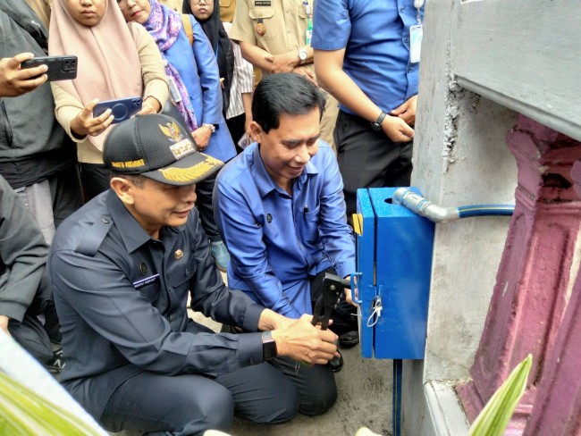 Pemasangan secara simbolis oleh Pj Wali Kota Malang Wahyu Hidayat didampingi Dirut Perumda Tugu Tirta M. Nor Muhlas.(Foto: Riski Wijaya/MalangTIMES).