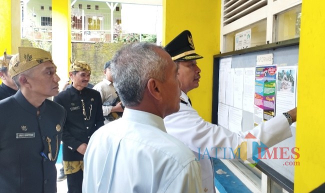 Pj Wali Kota Malang Wahyu Hidayat didampingi Sekretaris Daerah (Sekda) Erik Setyo Santoso dan Kepala Disporapar Kota Malang Baihaqi saat melihat sejarah Gedung KNPI (foto: Hendra Saputra/JatimTIMES)