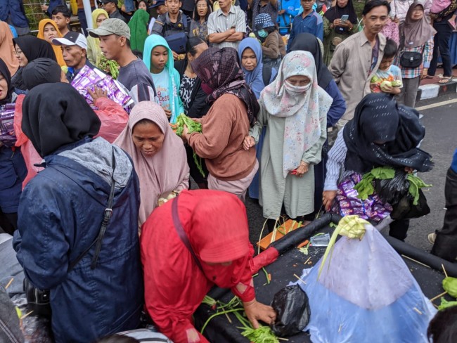 Warga berebut hasil bumi saat Grebek Kupat Tumpeng Syawalan Kota Wisata Batu.