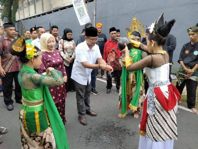 Ahmad Farih Sulaiman didampingi sang ibu Latifah Shohib saat melakukan serangkaian tradisi sebelum meneyerahkan berkas ke Kantor DPC PKB Kota Malang.(Foto: Riski Wijaya/MalangTIMES).