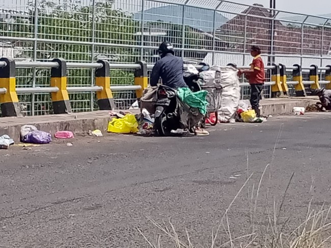 Kondisi jembatan Pasar Gadang dipenuhi sampah yang turut dimanfaatkan oleh pemulung.(Foto: Riski Wijaya/MalangTIMES).