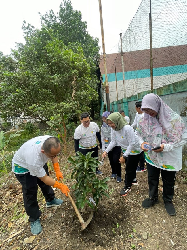 Tampak beberapa karyawan sedang melakukan tanam pohon alpukat di area kantor PLN UP3 Malang. (Foto: istimewa)