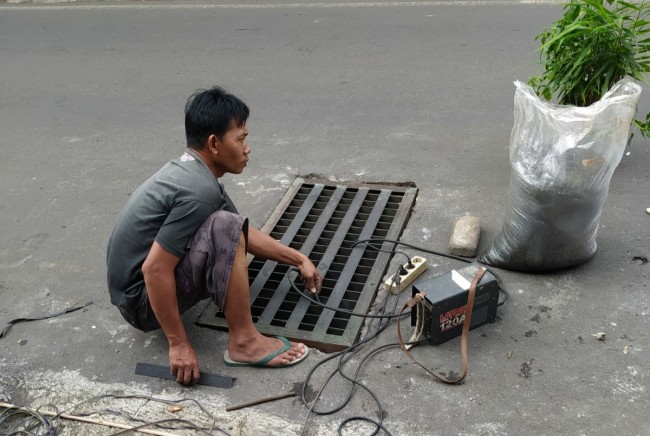 Warga RW 1 Kelurahan Merjosari melakukan perbaikan grill drainase.(Foto: Istimewa).