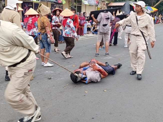 Teatrikal zaman penjajahan pada Pawai Budaya Kelurahan Tlogomas 2025 (foto: Hendra Saputra/JatimTIMES) 