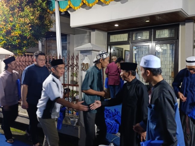 Tri Wediyanto (jubah hitam) saat menyalami satu per satu warga (foto: Hendra Saputra/JatimTIMES) 