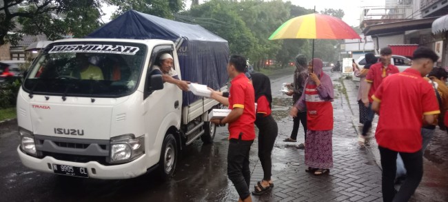 Momen pegawai Alfamart membagikan nasi kotak kepada para pengguna jalan. (Foto: istimewa)