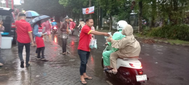 Momen pegawai Alfamart membagikan makanan dan minuman kepada pengguna jalan. (Foto: istimewa)