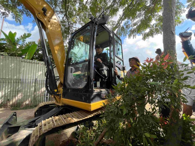 Wali Kota Malang Wahyu Hidayat mengendarai backhoe untuk membongkar Kantor UPT Pasar Gadang.(Foto: Ahmad Amin/MalangTIMES).