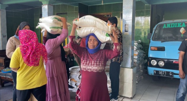 Momen warga Bareng, Kedungkandang, Kota Malang mengambil bantuan beras. (Foto: Amin/JatimTIMES)