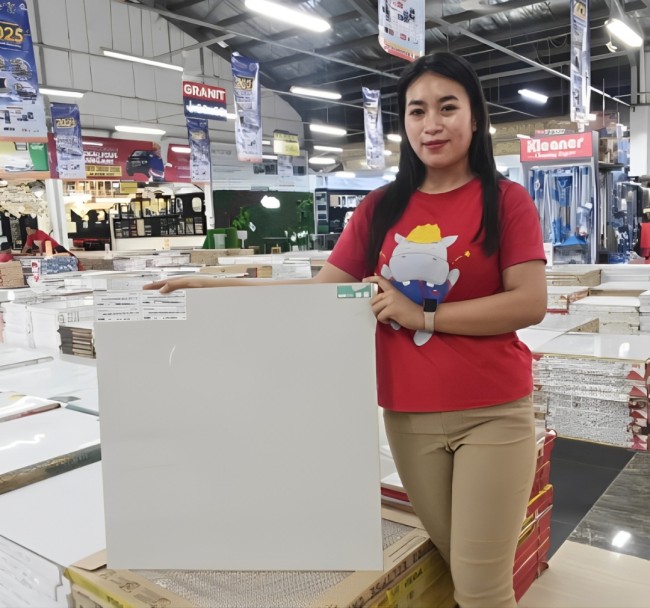 Staf Graha Bangunan Blitar menunjukkan produk granit Melitz Eclipse Cream KW Super yang saat ini sedang dipasarkan dengan harga promo, cocok untuk mempercantik interior rumah dengan nuansa elegan dan minimalis. (Foto: Aunur Rofiq/JatimTIMES) 