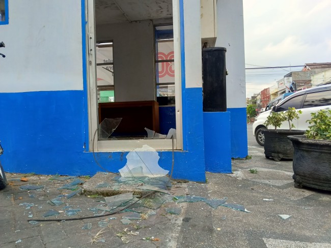 Kondisi pintu kaca pada Pos Satlantas Polres Malang yang pecah usai dilempar batu oleh orang tak dikenal pada Minggu (31/8/2025). (Foto: Ashaq Lupito/JatimTIMES)