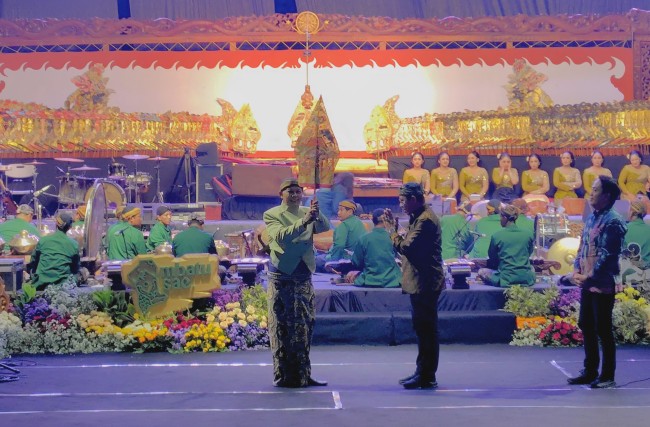 Penyerahan gunungan memulai Pagelaran Wayang Kulit Lakon Wahyu Makutharama dibawakan dalang bapak-anak untuk memeriahkan Resepsi HUT ke-24 Kota Batu, Jumat (17/10/2025).(Foto: Prasetyo Lanang/JatimTIMES)