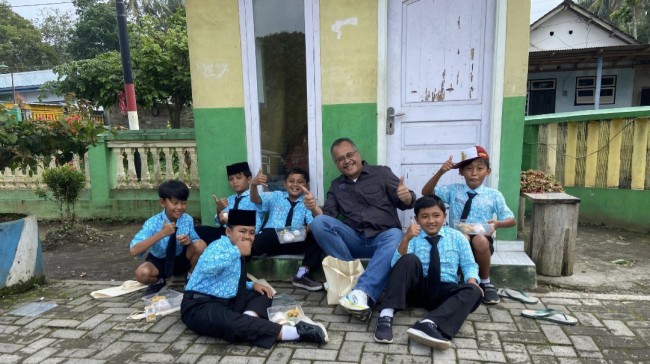 Momen Kepala Bidang Pengolahan dan Pemasaran Hasil Peternakan Dinas Peternakan Provinsi Jawa Timur, Nur Ismanto, S.Pt, MM, foto bersama siswa penerima paket gizi. (Foto: ist) 