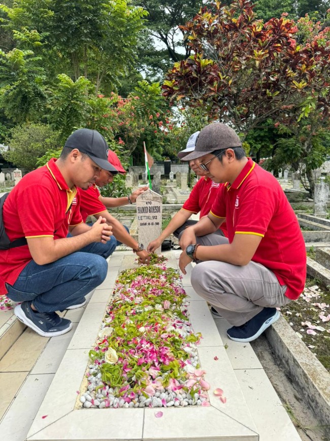 aksi tabur bunga para karyawan Alfamart di Taman Makam Pahlawan. (Foto istimewa) 