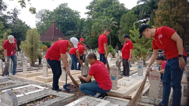 aksi para karyawan Alfamart membersihkan makam di Taman Makam Pahlawan dalam rangka memperingati Hari Pahlawan Nasional. (Foto istimewa) 