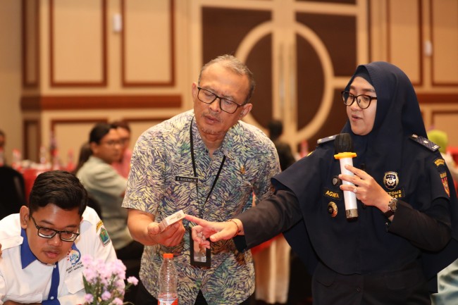 Agnita Adityawardani dari Kantor Bea Cukai Tipe Madya Cukai Malang menunjukkan pita cukai pada rokok. (Foto: ist)