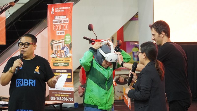 Momen driver ojol perempuan mencoba VR untuk melihat  layout rumahnya dulu. (Foto: ist)