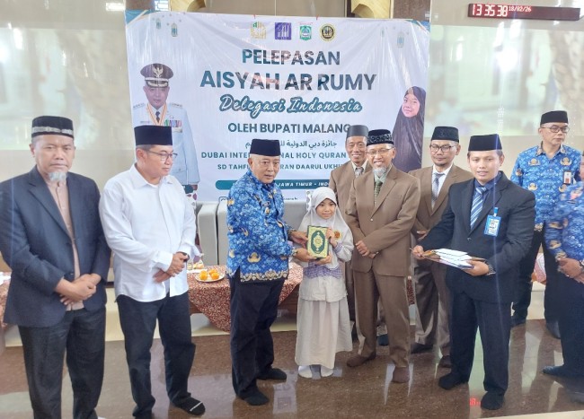 Bupati Malang HM. Sanusi saat menyerahkan kitab suci Al-Qur'an dan uang tunai sebesar Rp 32 juta kepada Aisyah Ar-Rumy di Pondok Pesantren Daarul Ukhuwwah, Desa Asrikaton, Kecamatan Pakis, Kabupaten Malang, Rabu (18/2/2026). (Foto: Tubagus Achmad/JatimTIMES)