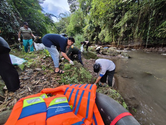 Para peserta mengumpulkan sampah yang tercecer di sepadan Kali Metro.(Foto: Riski Wijaya/MalangTIMES)