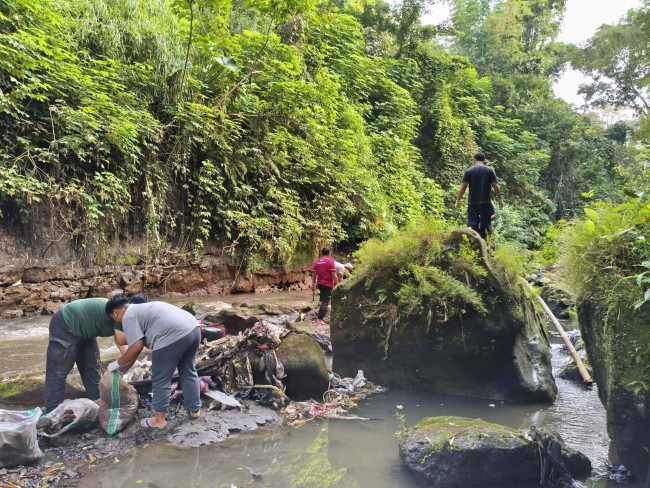 Para peserta mengumpulkan sampah yang tercecer di sepadan Kali Metro.(Foto: Riski Wijaya/MalangTIMES)