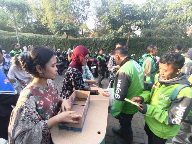 Penyaluran bantuan oleh Tomoland kepada ojol.(Foto: Riski Wijaya/MalangTIMES).