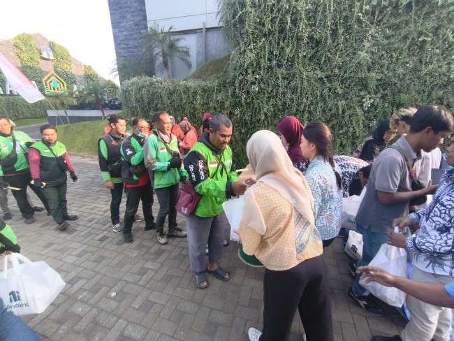 Penyaluran bantuan oleh Tomoland kepada ojol.(Foto: Riski Wijaya/MalangTIMES).